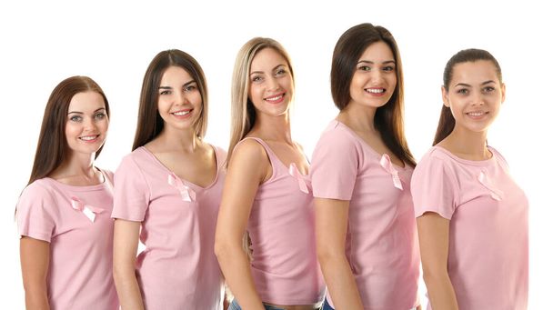 Kauniita nuoria naisia vaaleanpunaisissa paidoissa valkoisella taustalla. Rintasyövän käsite
 - Valokuva, kuva