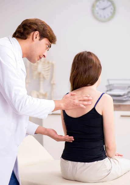 Female patient visiting young handsome doctor chiropractor - Foto, Imagem