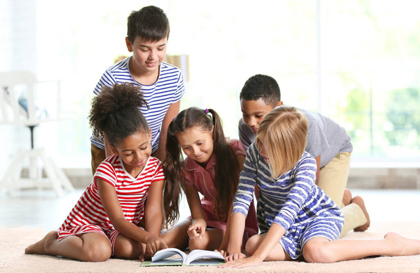 Lindos niños leyendo libro en casa
 - Foto, Imagen