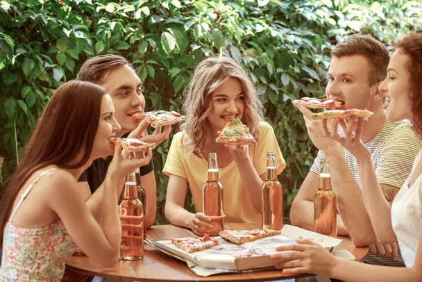Amigos sentados no café com cerveja fresca e pizza saborosa
 - Foto, Imagem
