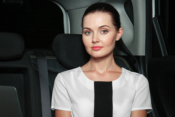 Piękny biznes kobieta siedzi na tylnym siedzeniu samochodu - Zdjęcie, obraz