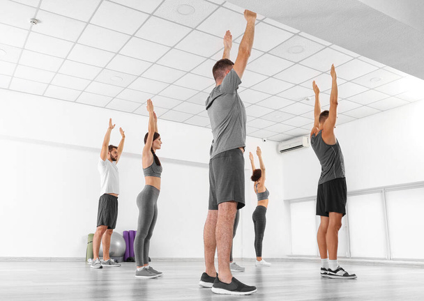 Gruppe von Menschen, die Übungen im Fitnessstudio machen - Foto, Bild