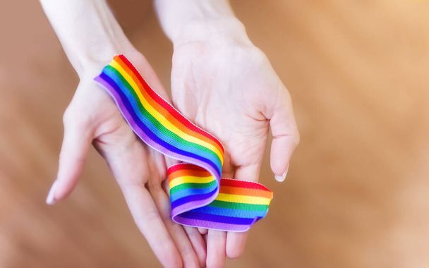 Рука держит радугу из ЛГБТ-лент на фоне СВЕТА. Копировать место для текста. Концепция гомосексуалистов и ЛГБТ
. - Фото, изображение