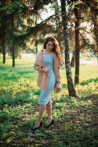 Beautiful young girl in a blue dress in a spring park - Foto, Imagen