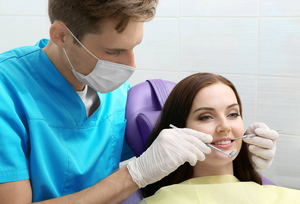 Dentist examining patient teeth in clinic - Φωτογραφία, εικόνα