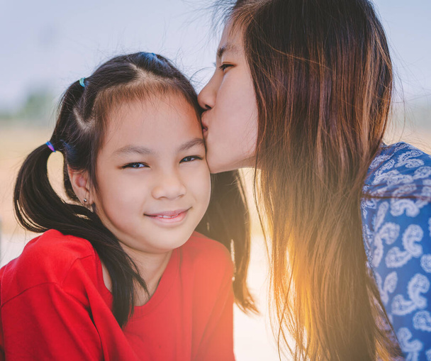 Aasian äiti ja duaghter suutelee ja halailee rakkautta ja kiintymystä ja perheen yhdessä käsite
 - Valokuva, kuva