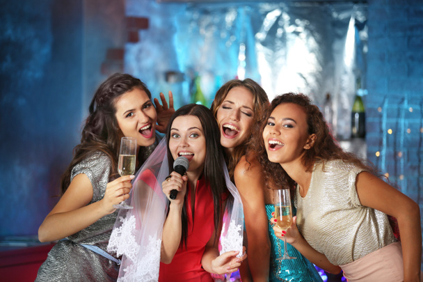 Beautiful girls with microphone  in nightclub - Foto, afbeelding
