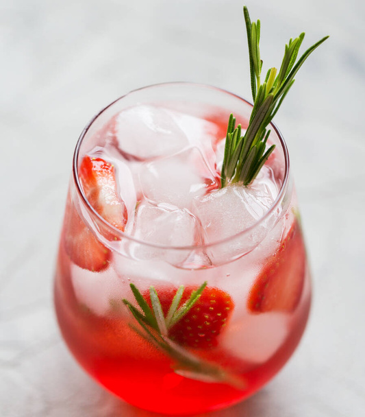 Macro cocktail with strawberry, ice and rosemary. Concept of recipe blank of lemonade with strawberry - Photo, Image