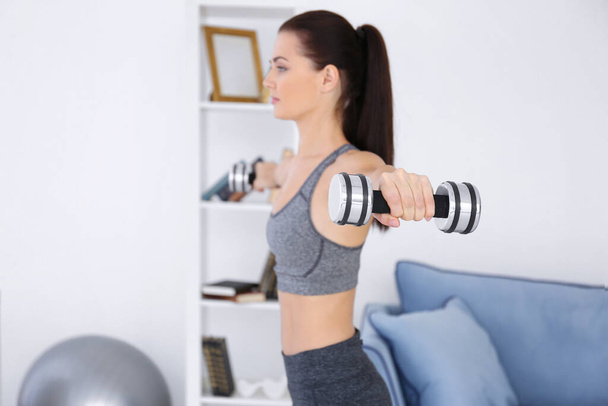 Attractive fitness woman exercising at home - Fotó, kép