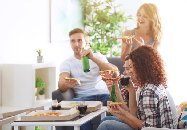Amigos comiendo sabrosa pizza en casa fiesta
 - Foto, Imagen