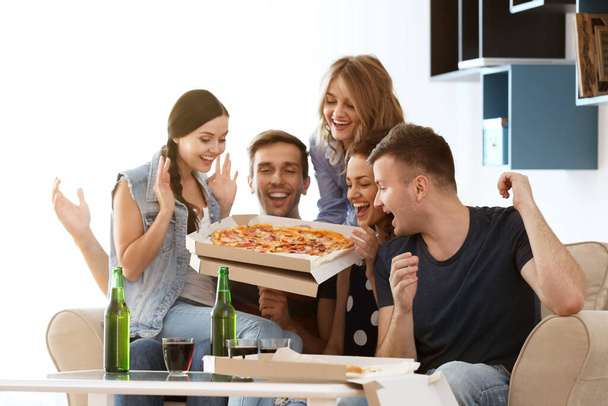 Φίλοι τρώνε νόστιμη πίτσα στο σπίτι κόμμα - Φωτογραφία, εικόνα