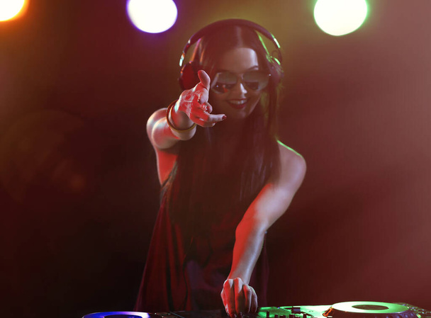 Mooie jonge DJ speelt muziek in nachtclub - Foto, afbeelding