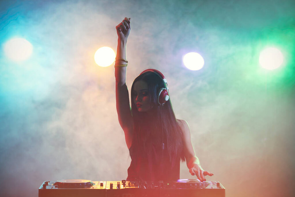Jolie jeune DJ jouant de la musique en boîte de nuit
 - Photo, image