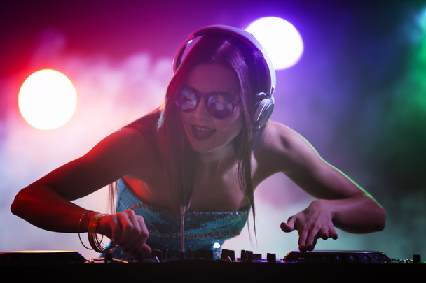 Pretty young DJ playing music in nightclub - Photo, Image