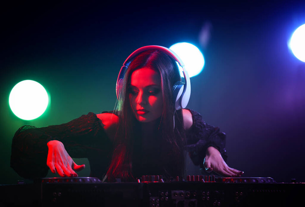 Прелестный молодой диджей играет музыку в ночном клубе
 - Фото, изображение