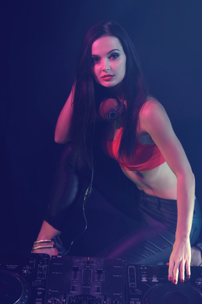 Bella giovane donna con console DJ su sfondo scuro
 - Foto, immagini