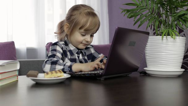 Tyttö tekee oppitunteja kotona digitaalisen kannettavan tietokoneen avulla. Etäopetus
 - Valokuva, kuva