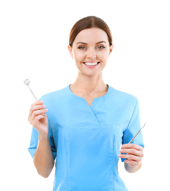 Female dentist with tools on light background - Фото, зображення
