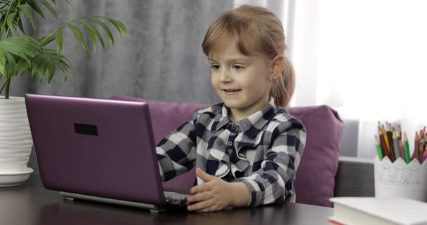 Девочка изучает домашнее задание с помощью цифрового ноутбука. Дистанционное образование
 - Фото, изображение