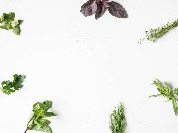 Frame of bunches of fresh raw herbs - tarragon, thyme, dill, cilantro, parsley and purple basil on a textured background. Top view. Copy space - Zdjęcie, obraz
