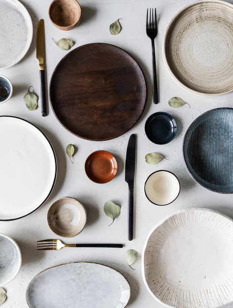 Flat lay of various empty plates, bowls and utensils on gray background. Top view. - Photo, Image