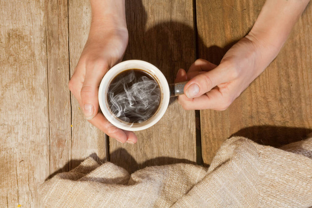 the girl's hands hold a Cup of hot coffee - Foto, Imagem