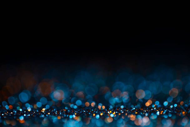 Decoration twinkle glitters background, abstract shiny backdrop with circles,modern design wallpaper with sparkling glimmers. Black, blue and golden backdrop glittering sparks with blur effect. - Photo, image
