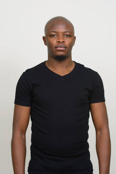Studio shot of young handsome bald African man against white background - Foto, Imagen