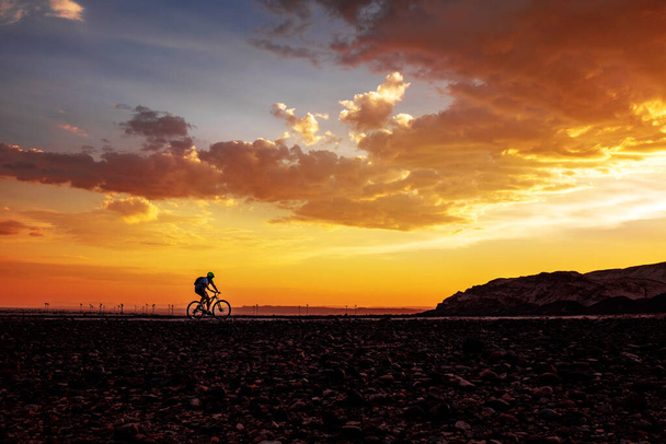 Silhouette of cycling man on bike on beautiful sunset background - Foto, Bild