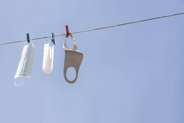 Washed medical masks are dried on a blue sky background - Foto, Imagem