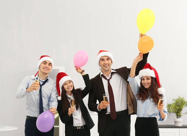 Geschäftsleute mit Nikolausmützen bei Büroparty - Foto, Bild