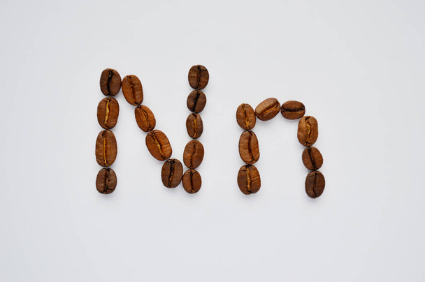 letras n hechas de granos de café sobre el fondo blanco
. - Foto, Imagen