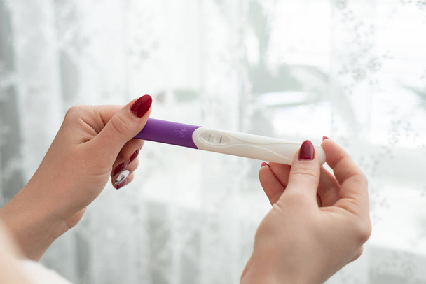 Pregnancy test in female hand on blurred background - Photo, Image