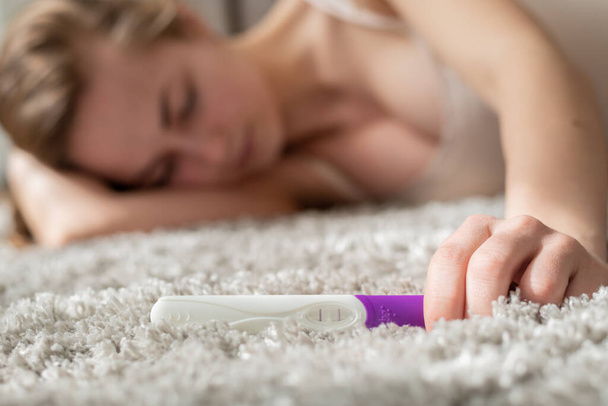 Young woman with pregnancy test in hands - Valokuva, kuva