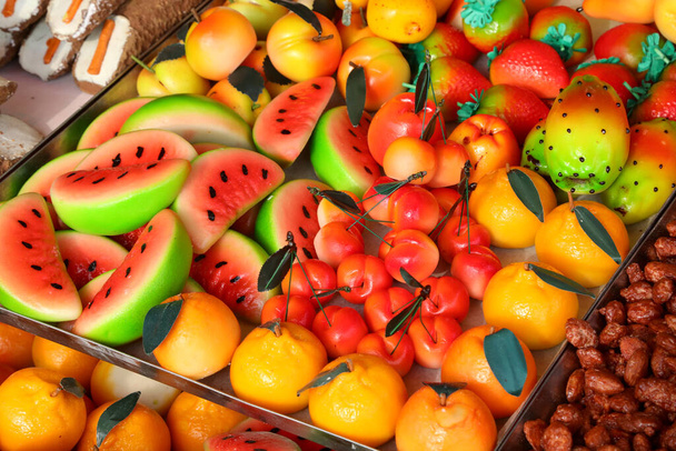 πολλά αρτοσκευάσματα φτιαγμένα με αμυγδαλόπαστα και με πολλές μορφές πολύχρωμων φρούτων και λαχανικών προς πώληση στο ιταλικό περίπτερο - Φωτογραφία, εικόνα