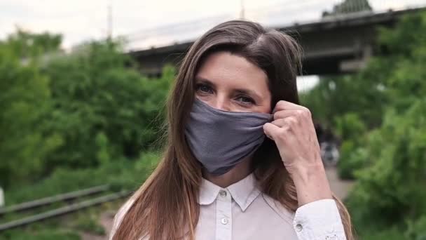 Tıbbi maske, koronavirüse karşı koruma. Salgının sonu. Dışarıdaki bir kadının portresi. - Video, Çekim
