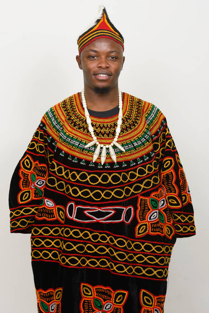 Beyaz arka planda geleneksel kıyafetler giyen yakışıklı Afrikalı genç adamın stüdyo fotoğrafı. - Fotoğraf, Görsel