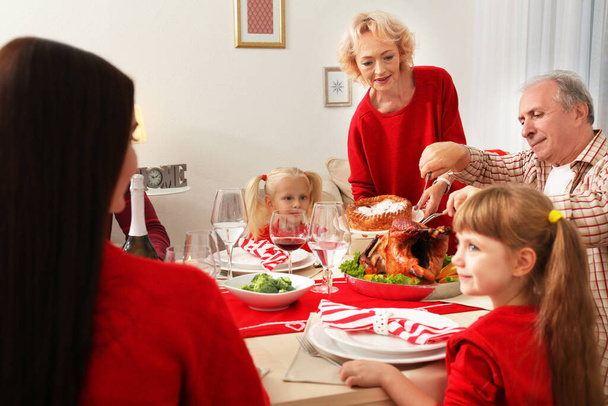 Familia teniendo cena de Acción de Gracias en la sala de estar
 - Foto, Imagen
