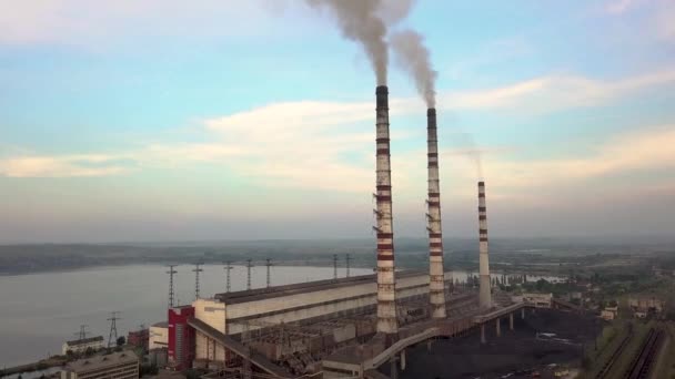 Kömür santralinden gelen gri dumanlı yüksek baca borularının havadan görüntüsü. Fosil yakıtla elektrik üretimi. - Video, Çekim