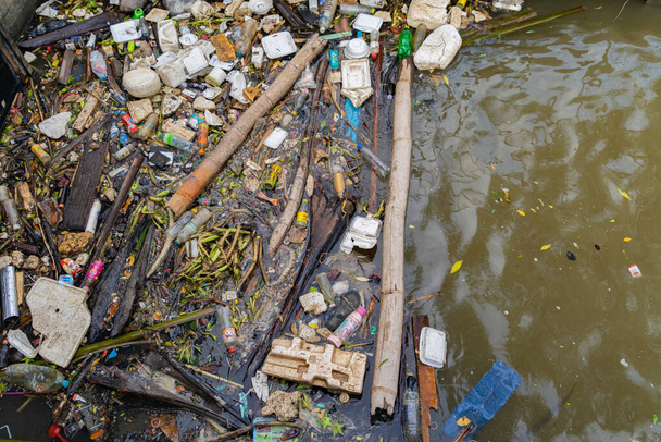 環境汚染の概念では、都市部の川や湖のゴミ捨て場、ビニール袋、ゴミ、ゴミの大規模な。汚れた水の中に浮かぶ. - 写真・画像