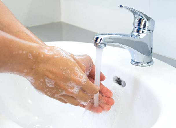 Hygieeniset käsitteet Pese kädet saippualla hanan alla puhtaalla vedellä viruksilta suojaamiseksi
. - Valokuva, kuva