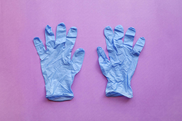 Blue medical gloves on pink background. - 写真・画像