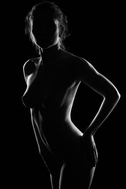 beautiful naked female body on black background - Foto, afbeelding
