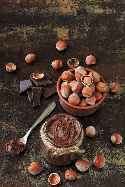 Chocolade notenpasta, hazelnoten en pure chocolade. Ingrediënten concept van natuurlijke chocolade notenpasta. Energievoedsel. Eco-levensmiddelen. - Foto, afbeelding