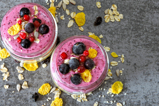 Berry yogurt with granola, flakes and berries. Jars with healthy bright smoothies and yogurt. Purple Smoothie Keto breakfast or dessert. Keto diet. - Photo, Image
