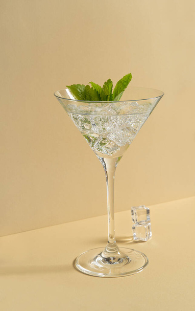 Fresh cocktail drink with ice and green mint leaves. Trendy still life - Foto, afbeelding