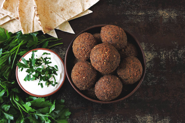 Fresh falafel balls, pita, sauce and herbs. Vegan falafel. Middle Eastern cuisine. - Photo, Image
