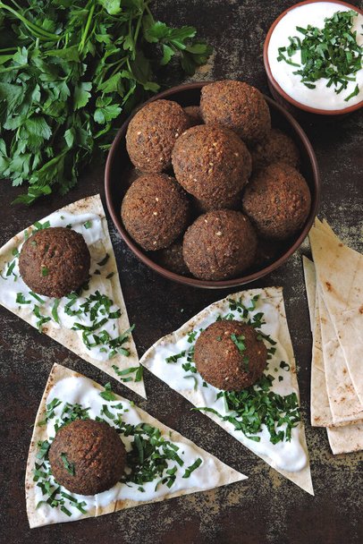Verse falafelballen, pita, saus en kruiden. Veganistische falafel. Midden-Oosten keuken. - Foto, afbeelding