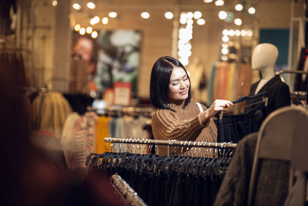 Uma mulher a comprar roupa. Shopper olhando para a roupa interior
 - Foto, Imagem
