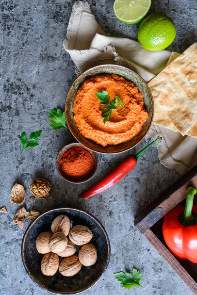Muhammara, здоровый грецкий орех и жареный красный перец соус подается с лепешками в керамической миске
 - Фото, изображение